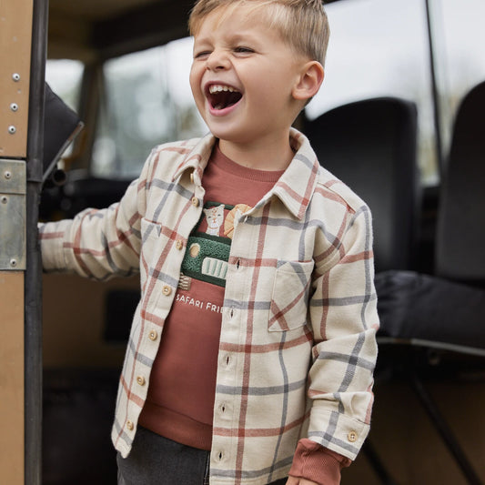 Kind trägt Little Dutch Overshirt Beige kariert im Freien