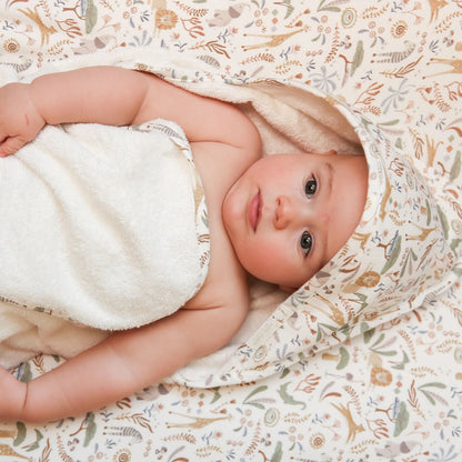 Baby eingewickelt in Little Dutch Badeponcho Safari Wonders