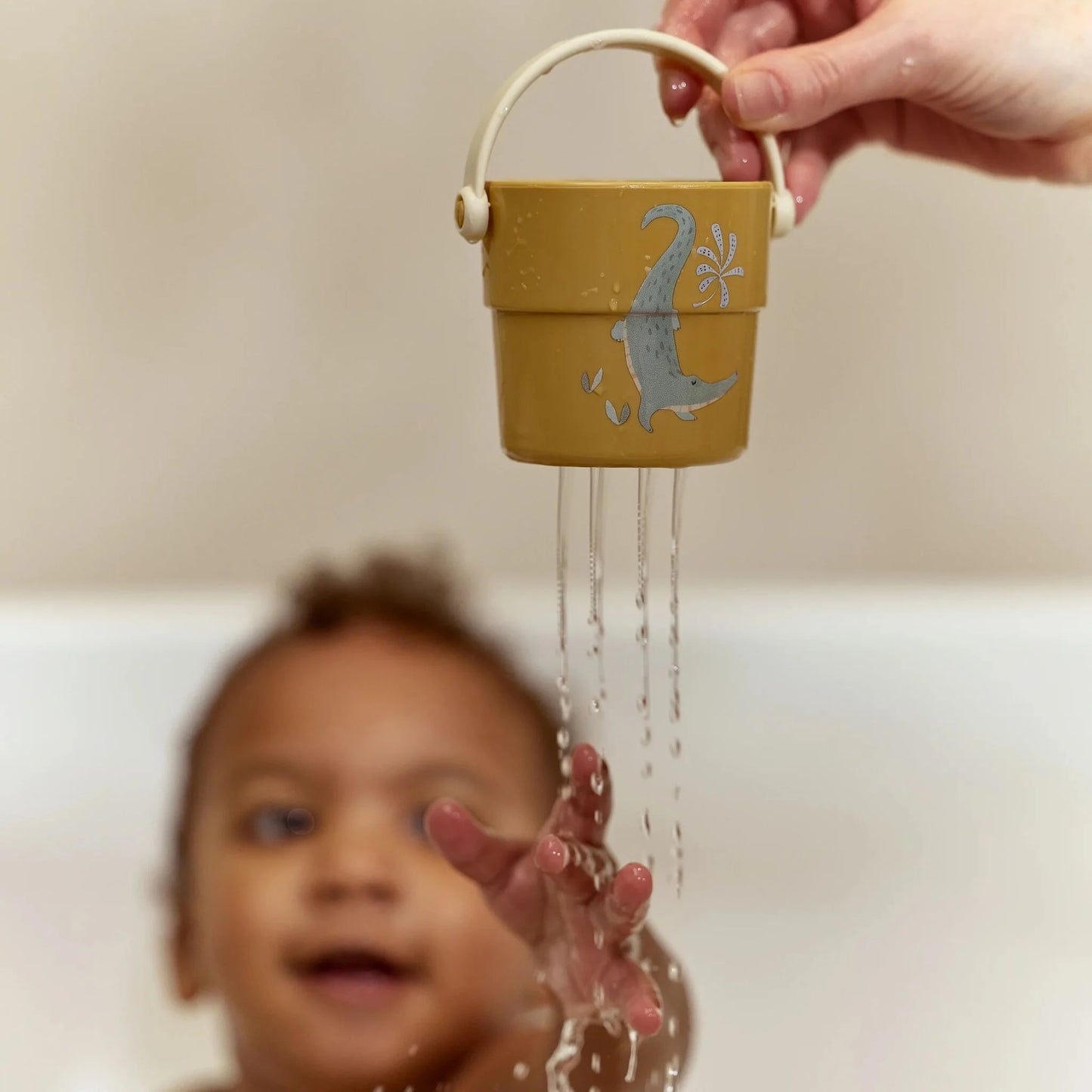Little Dutch Badebecher in Kinderhänden beim Gießen
