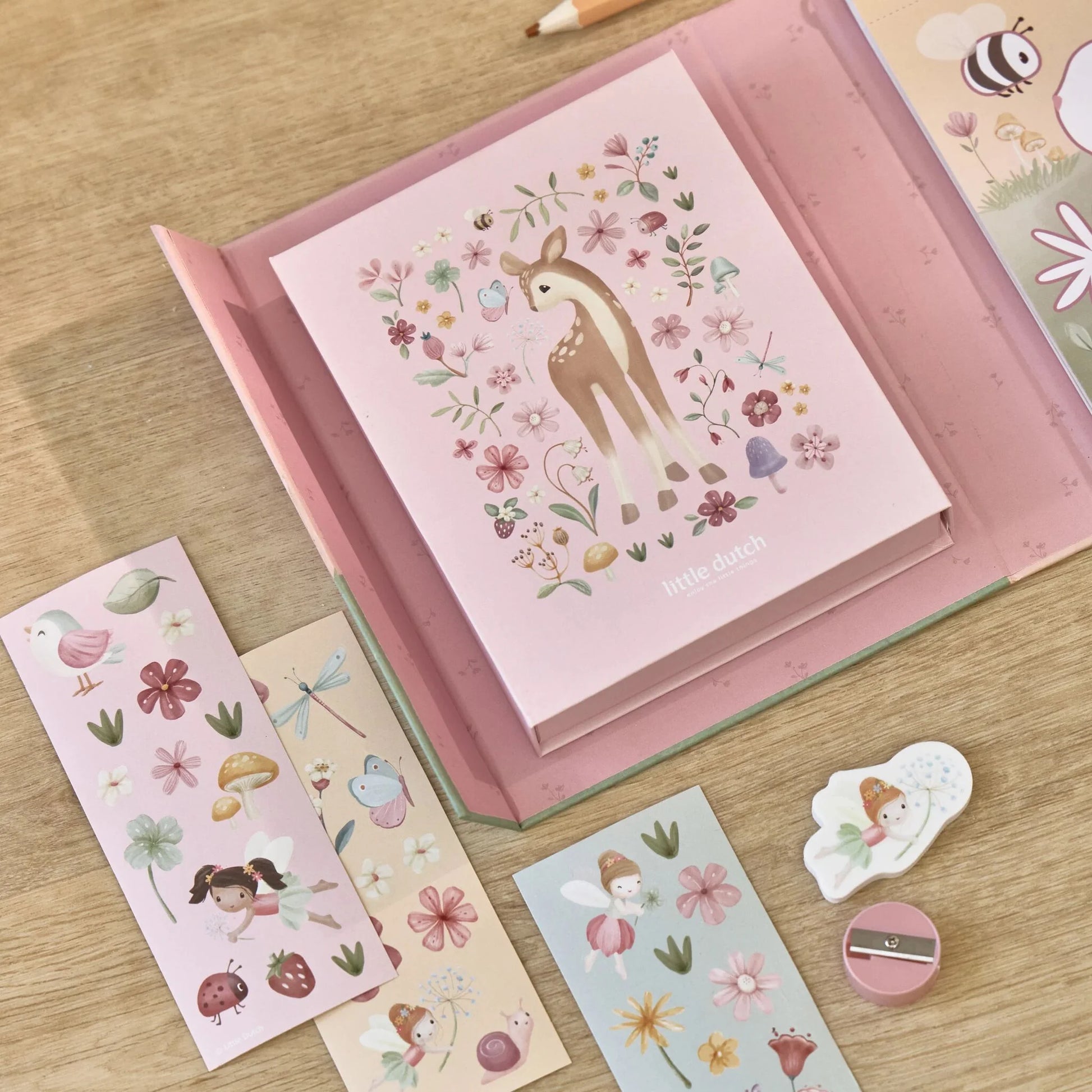 Kind malt im Malbuch Rosa mit bunten Stiften