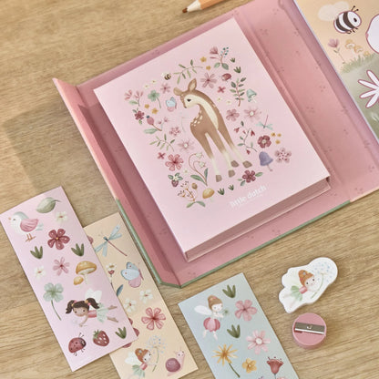 Kind malt im Malbuch Rosa mit bunten Stiften