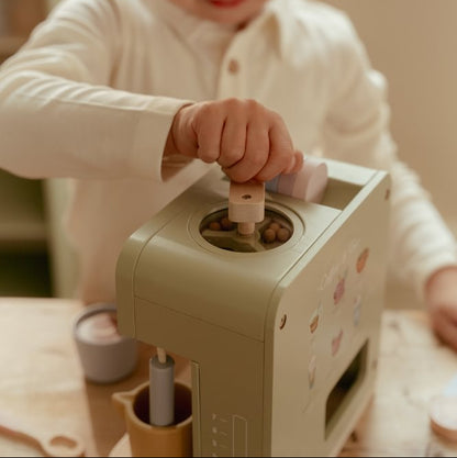 Kind greift an den Holzgriff der Spiel-Kaffeemühle oben auf der grünen Little Dutch Kaffeemaschine.

