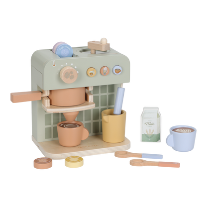 Grüne Little Dutch Kaffeemaschine in schräger Vorderansicht mit orangefarbener Tasse unter dem Auslauf, gelber Milchkanne und weiterem Spielzubehör.
