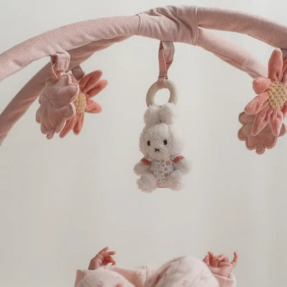 Weiße Miffy-Figur zwischen rosa Blumen und Kleeblättern am Lucky Blossom Spielbogen von Little Dutch.