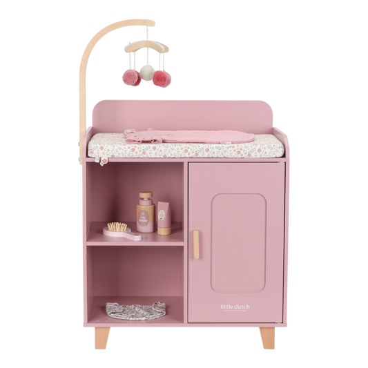 Little Dutch Puppenwickeltisch in Rosa mit Mobile, Soft Flowers Wickelkissen und Pflegezubehör in der Frontansicht.